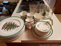 Overview of Christmas Tree china set and Christmas glasses on kitchen counter.