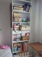 White bookshelf with sewing supplies and baskets