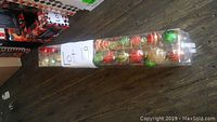 Two long plastic boxes containing a total of 140 shatterproof Christmas ornaments in various colors and styles.