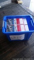 Blue plastic bin containing four unopened retail boxes of all purpose light clips for 16 ft runs, each box labeled and new.
