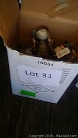Box with visible Santa Claus figurines and Christmas ornaments inside.