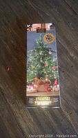 Front packaging view showing the miniature holiday tree and ornaments inside clear box