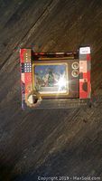 Photo of boxed F.A.O Schwarz Musical Figurine TV, showing front Christmas village scene, box and price tag.