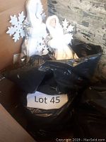 Black bag labeled Lot 45 containing Christmas decorations with visible angel figures and snowflake ornaments