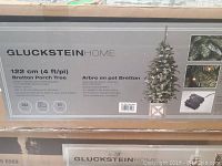 Box showing Gluckstein Home logo and product information for 4 ft Bretton Porch Tree including name, height (122 cm/4 ft), and that it is battery operated with LEDs.