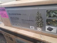 Box front showing branding and product image of the 4ft Bretton Porch Tree with LED lights and decorative pot