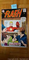 Photo of The Flash #149 comic book front cover showing The Flash on TV and three men watching, dated December 1964.