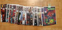 Photo shows 20 Spawn comic books issues #1 to #20, each individually bagged and boarded, laid out side by side on a wooden surface.