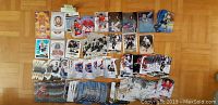 Top-down view of over 150 hockey trading cards arranged in stacks and spreads on a wooden floor, featuring star players like Crosby, Ovechkin, Kane, McDavid, and Price. Cards include both insert and base types from multiple recent NHL card sets.