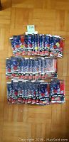 Photo showing 36 unopened packs of 1998/99 Upper Deck Series 2 hockey cards laid out on a wooden floor.
