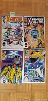Four comic books with covers visible showing X-Factor title and characters including Apocalypse and Archangel.
