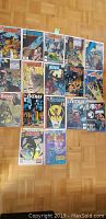 Group photo of 17 Batman comic books featuring various issues and two Annuals arranged on wooden floor showing front covers.