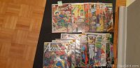 Photo showing 21 Superman comic books from the Action Comics series arranged on a table, sleeved in protective bags.