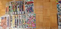 Photo showing 22 X-Men and related comic books in protective sleeves, arranged on parquet floor.