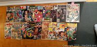 Photo showing all 18 first issue comics laid out side by side, covers fully visible. Titles include a cross section of Marvel and other series.