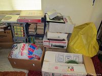 Photo showing boxes of albums, books, a bean bag in yellow bag, and assorted boxes