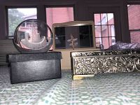 View of silver embossed jewelry box, glass art paperweight on black box, and pink Godinger music box with spinning dancer inside.