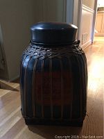 Side view showing navy blue basket with brown woven strips and vertical wooden slats with red decorative panels.