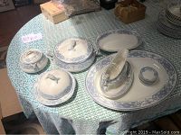 Full set view on table showing covered dishes, platter, gravy boat, and sauce bowls
