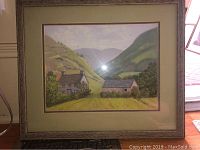 Framed detailed landscape painting of Welsh farmhouse scene in valley with hills.