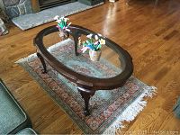Oval hardwood coffee table on silk area rug