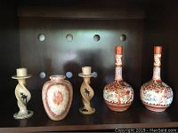 Front view of the lot, showing two Asian vases, small onyx vase, and two twisted candlesticks on shelf.