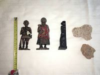 Top view of five figurines arranged on a white surface with measuring tape showing size