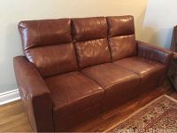 Front view of brown leather sofa with recliners closed