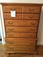 Front view of oak high boy chest showing all drawers and brass handles, with note attached indicating missing handle included.