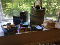 Wide shot of window sill showing an assortment of books, basket, hats, and boxes with games.