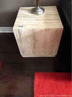 Front view of one stone end table showing natural stone texture and square shape.