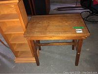 Rustic pine table with visible wood grain and some wear, including loose joints on sides, rectangular top with straight legs and cross supports.