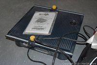 Mastercraft wet tile saw showing the ribbed water tray and yellow adjustment knobs.