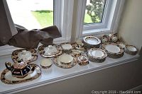 Full assortment displayed on windowsill: teapot, covered dishes, bowls, plates, cups and saucers