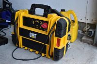 Front angle of yellow and black CAT CJ3000 charger with handle and side cord wrap