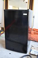 Front view of black Magic Chef bar fridge showing full door and handle.