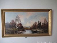 Full view of the framed landscape painting showing trees, river, and sky.