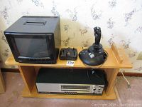 Full lot on wooden shelf: RCA TV 12 inch CRT, two joysticks, Telefunken radio below, wooden shelf.