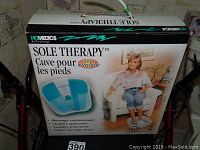 Photo of the Sole Therapy foot spa box showing brand, features, and promotional image of user.