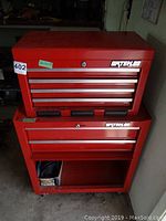 Front view of red Waterloo top chest stacked on bottom rolling cabinet, showing drawers and lock