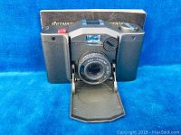 Front view of the vintage KIEV 35A camera with fold-out lens cover closed, showing lens and camera body details