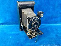 Front angle view of the vintage Vest Pocket Kodak Model B camera showing the lens, aperture settings, bellows, and folding mechanism.