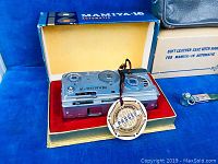 Mamiya-16 Automatic camera in original box with red velvet lining and 'Japan Camera Inspection Institute Passed' tag visible.