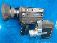 Photo showing Bell & Howell movie camera with large lens and rubber lens hood alongside smaller Bullseye movie camera.