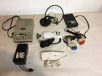 Photo showing six electronic devices including Sony Micro-Transcriber BM-815 tape recorder, battery tester, ThermaPro message unit, Pollenex personal massage unit with red and blue heads, white handheld device, and black device with wires.
