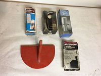 Photo shows five boxed items and a red hanging shelf on a light surface