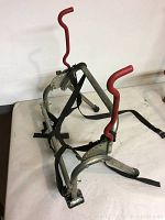 Bicycle rack with red padded hooks and straps on white surface