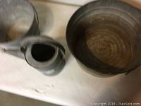 Top view photo showing galvanized watering can with long spout and a large galvanized basin pail