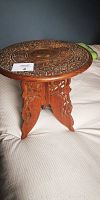 Full view of the wooden table showing the carved removable top and carved legs.