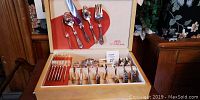 Opened box displaying the full 81-piece silverware set with mostly one style of flatware, including spoons, forks, and knives.